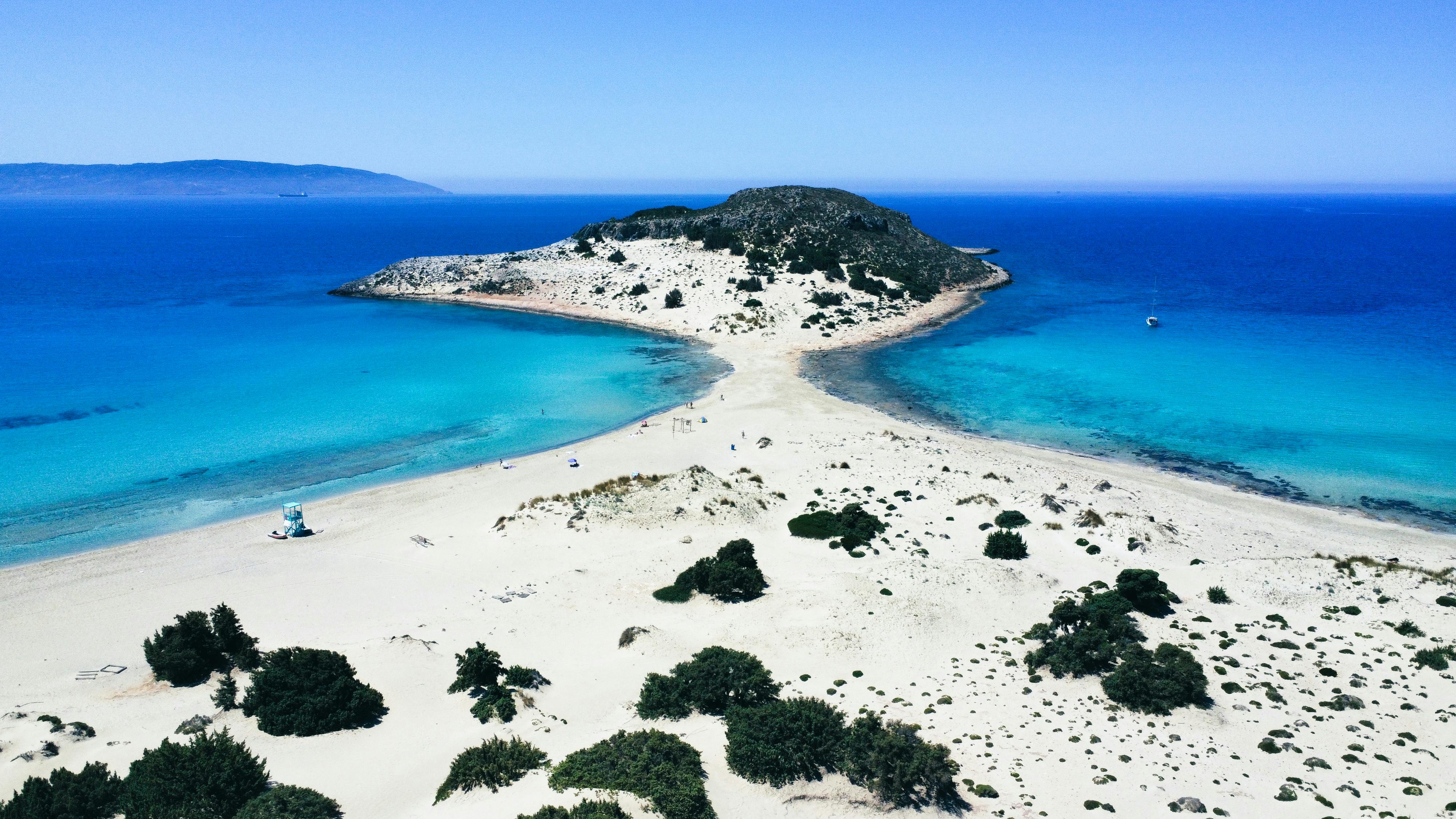 A sleek white yacht anchored in a turquoise bay